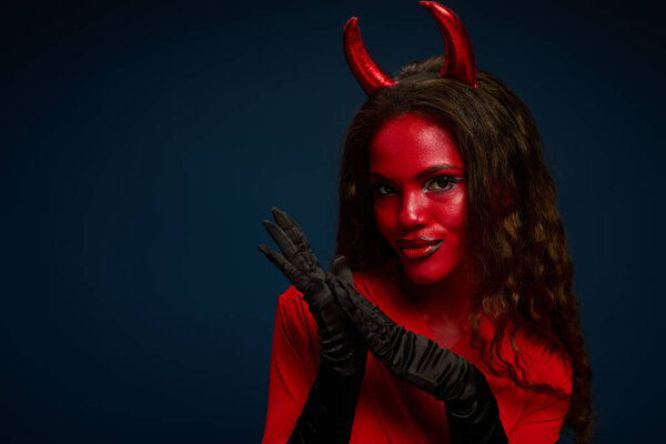 A captivating woman dressed in a striking Halloween outfit exudes confidence and allure.