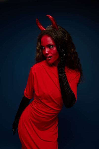 The beautiful woman, dressed in a striking red outfit, exudes confidence in her Halloween look.