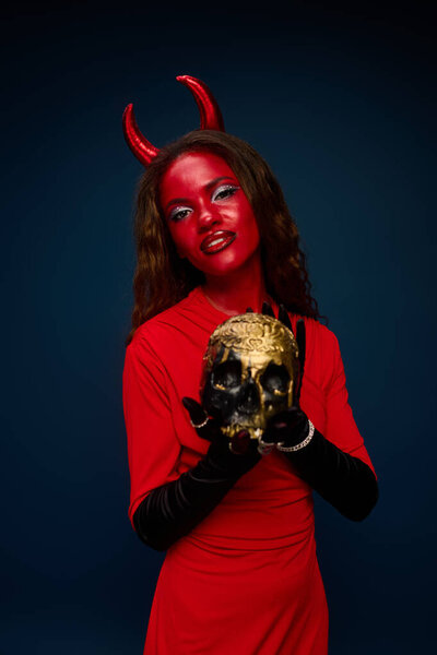 A stunning woman in a vibrant costume engages with a skull, embodying Halloweens spirit.