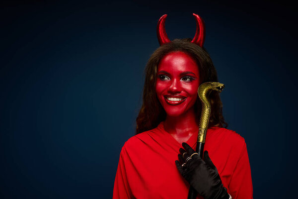 A gorgeous woman in a devil costume smiles happily.
