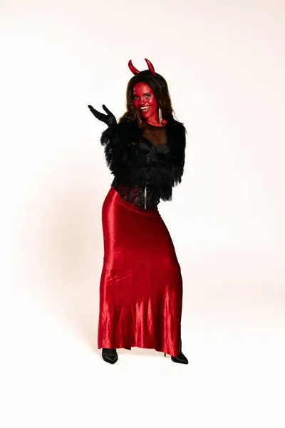 stock image Dressed in a bold red devil outfit, the woman radiates Halloween charm and playful energy.