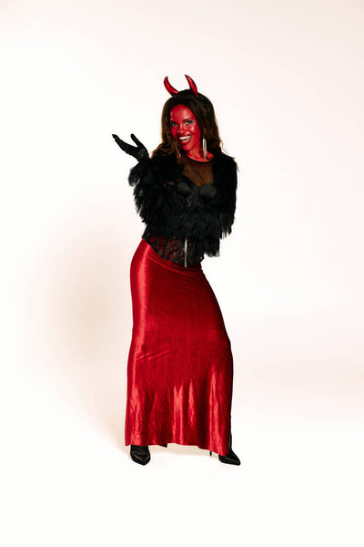 Dressed in a bold red devil outfit, the woman radiates Halloween charm and playful energy.