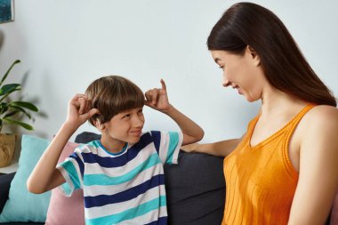 Bir anne, işitme bozukluğu olan küçük oğluyla neşeyle etkileşime girer..