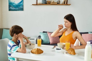 İşitme engelli bir çocuk annesiyle sıcak bir kahvaltı yapar ve aralarındaki bağı güçlendirir..