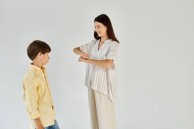 A young boy smiles as his mom gestures to him, fostering understanding and connection. clipart