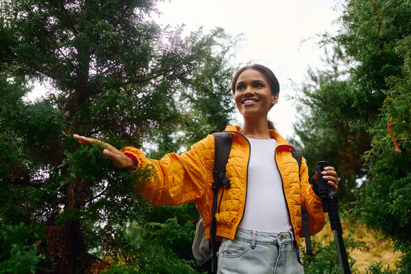 A spirited young woman enjoys a beautiful hike through colorful autumn foliage in a peaceful forest.