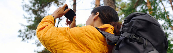 Молодая афроамериканка исследует яркий осенний лес, захватывая потрясающие окрестности.