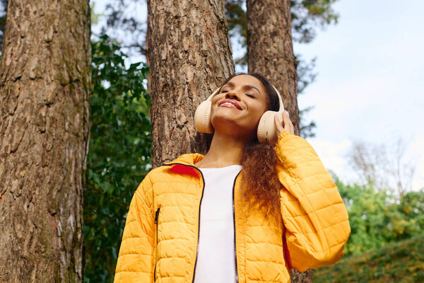 A young woman revels in the beauty of autumn while hiking through a colorful forest.