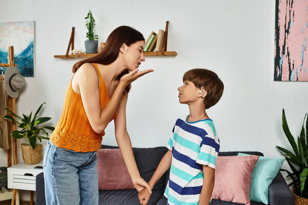 A mother interacts lovingly with her hearing impaired son, enjoying a joyful bonding moment.