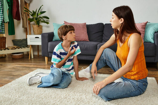 A mother engages her hearing impaired son in a supportive and loving conversation at home.
