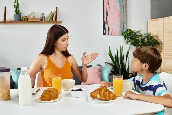 Stock image A mother shares a heartfelt moment with her son, encouraging communication during breakfast.