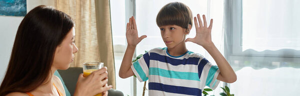 Маленький мальчик с нарушением слуха взаимодействует со своей матерью, делясь радостными моментами.