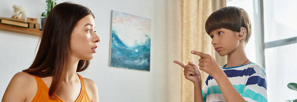 Мать вступает в содержательную беседу со своим слабослышащим сыном в помещении.