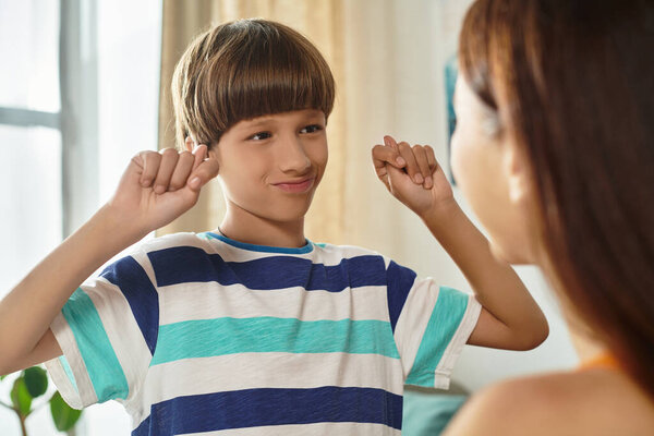 A young boy happily engages with his mother, showcasing their special bond indoors.