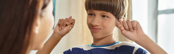 A mother engages lovingly with her hearing impaired son, sharing an intimate moment of connection.