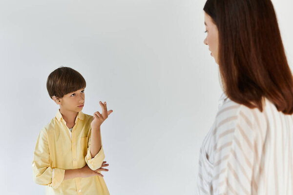 A little boy communicates through sign language, expressing his thoughts to his caring mother.