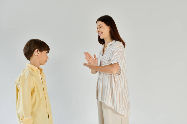 A caring mother engages with her son, who has hearing impairment, fostering connection and growth.