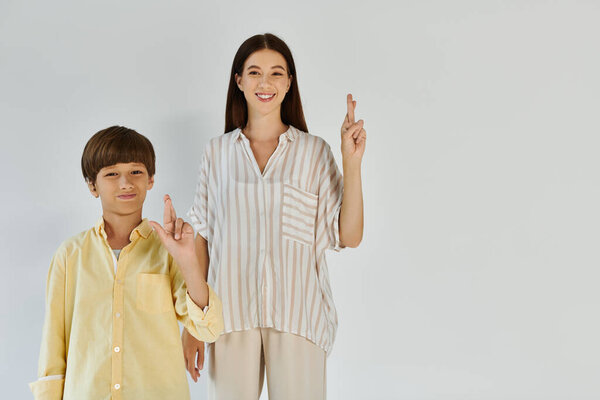 Мать и ее маленький сын показывают свою связь через обнадеживающий жест в заполненном светом пространстве..