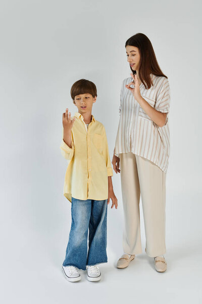 A mother and her son share a tender moment, communicating with sign language together.