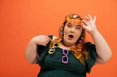 A beautiful plus size woman displays colorful glasses in her hair, exuding joy and surprise. clipart