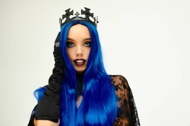 Dressed in a Halloween costume, a young woman with blue hair and a crown poses confidently. clipart