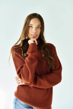 Beyaz arka planda poz veren zarif giyinmiş çekici bir kadın..