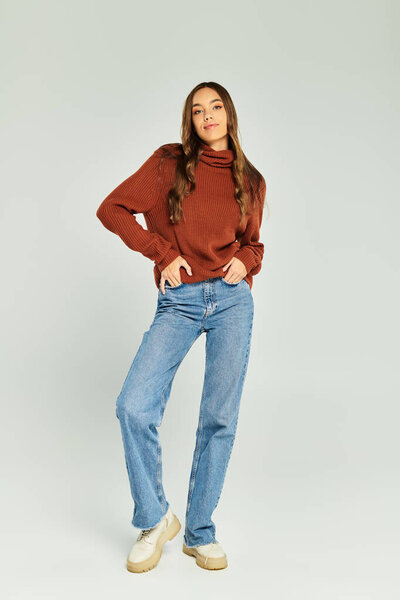 Красивая женщина в элегантной одежде позирует на белом фоне.