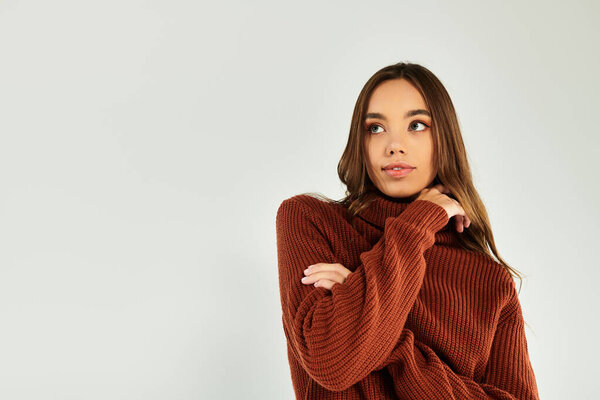 Красивая молодая женщина позирует в теплом свитере.