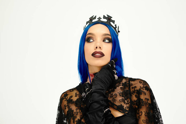 A stunning woman in a spooky Halloween costume flaunts her vibrant blue hair and dark makeup.