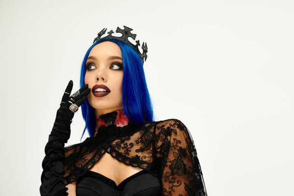 Одета в драматический костюм на Хэллоуин, молодая женщина источает очарование и таинственность с голубыми волосами.