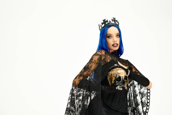Молодая женщина моделирует свой потрясающий готический костюм на Хэллоуин с яркой короной и темным макияжем.