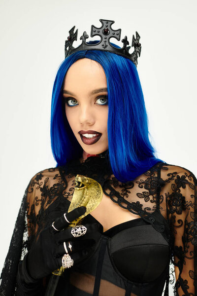 Женщина носит сложный костюм на Хэллоуин с драматической короной и яркими голубыми волосами.