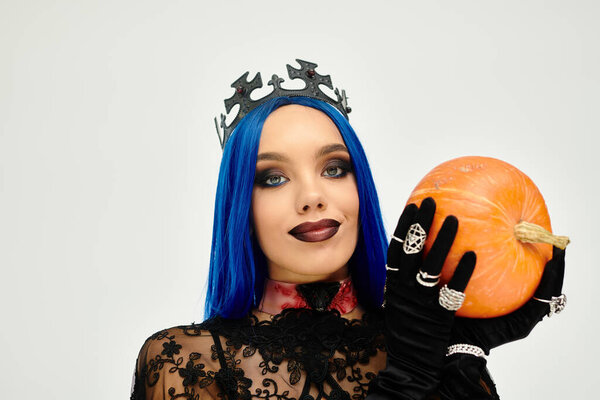 Эта потрясающая молодая женщина демонстрирует творческий костюм на Хэллоуин, держа в руках яркую тыкву.
