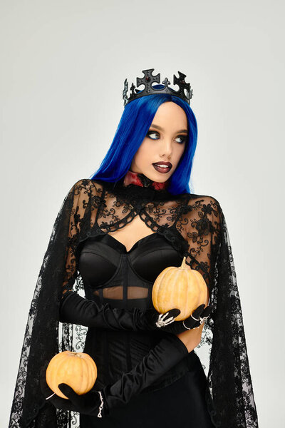Одета в потрясающий костюм на Хэллоуин, она привлекает внимание своей тыквой и игривой позой.