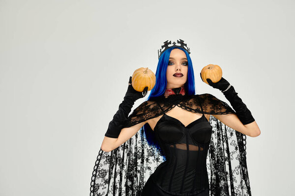 Женщина в детальном костюме на Хэллоуин держит тыквы, обнимая праздничный дух.
