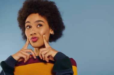 Genç bir kadın neşeli bir şekilde gülümserken duygusal yanını gösterir..