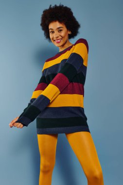 A young emotional woman in a striped sweater showcases her joy and style against a vibrant backdrop. clipart