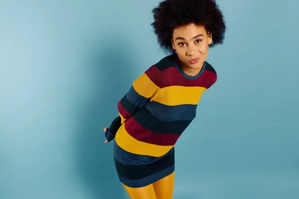 stock image A young emotional woman expresses feelings while dressed in vibrant, striped clothing.