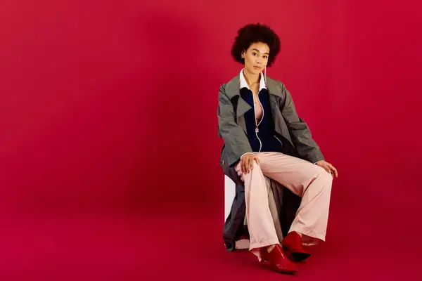 stock image A young woman expresses deep emotions while seated, dressed in fashion forward clothing.