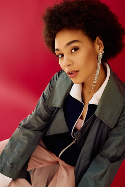 Молодая женщина с живым выражением лица творчески позирует на ярком фоне.