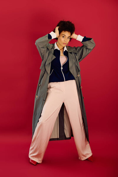 Молодая женщина выражает свои эмоции в поразительных позах, одетая модно в смелую обстановку.