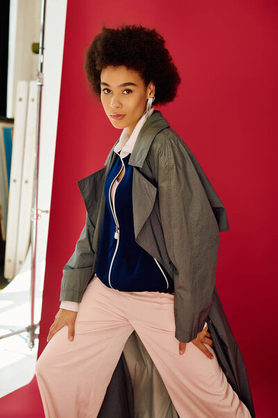 Молодая женщина с выразительным взглядом воплощает моду и эмоции против красочной обстановки.