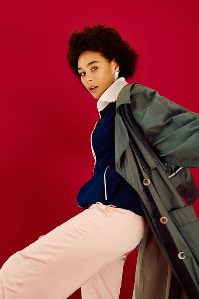 Молодая женщина выражает глубокие эмоции, демонстрируя свою модную одежду в ярких красках.