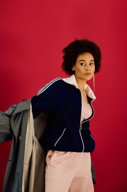 Genç bir kadın, parlak pembe bir arkaplan karşısında şık bir elbiseyle çeşitli duygular gösterir..