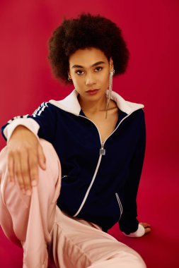 Şık giyinmiş genç bir kadın çarpıcı bir ortamda derin duygular ifade eder..