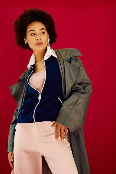 An expressive young woman stands confidently in a fashionable outfit, radiating emotion.