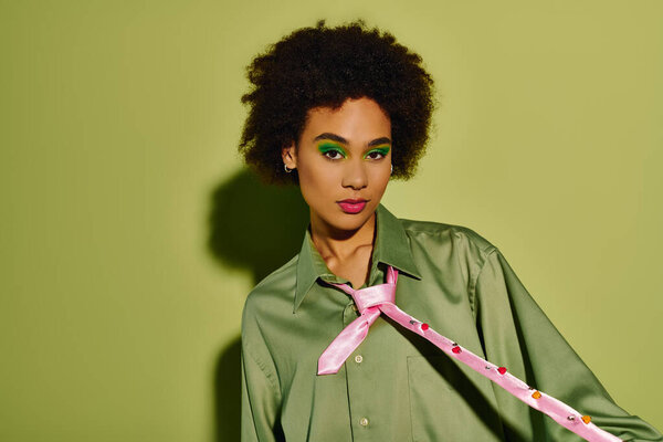 Молодая женщина с выразительными чертами показывает свою эмоциональную глубину в живой, зеленой атмосфере.