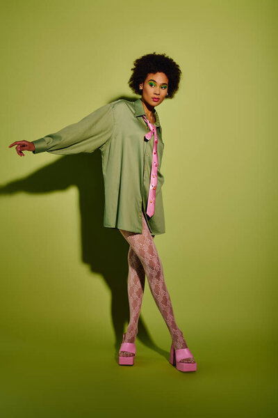 Молодая женщина выражает глубокие эмоции, находясь в уникальной позе в стильной одежде.