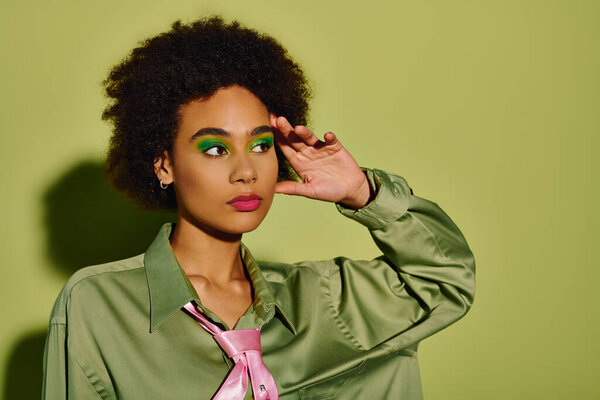 Молодая эмоциональная женщина демонстрирует смелый макияж и вдумчивое выражение в творческой обстановке.