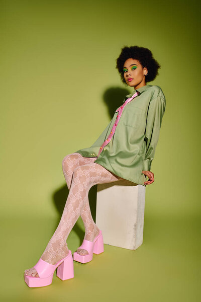 Молодая женщина выражает глубокие эмоции, демонстрируя стильный наряд в оживленной обстановке.